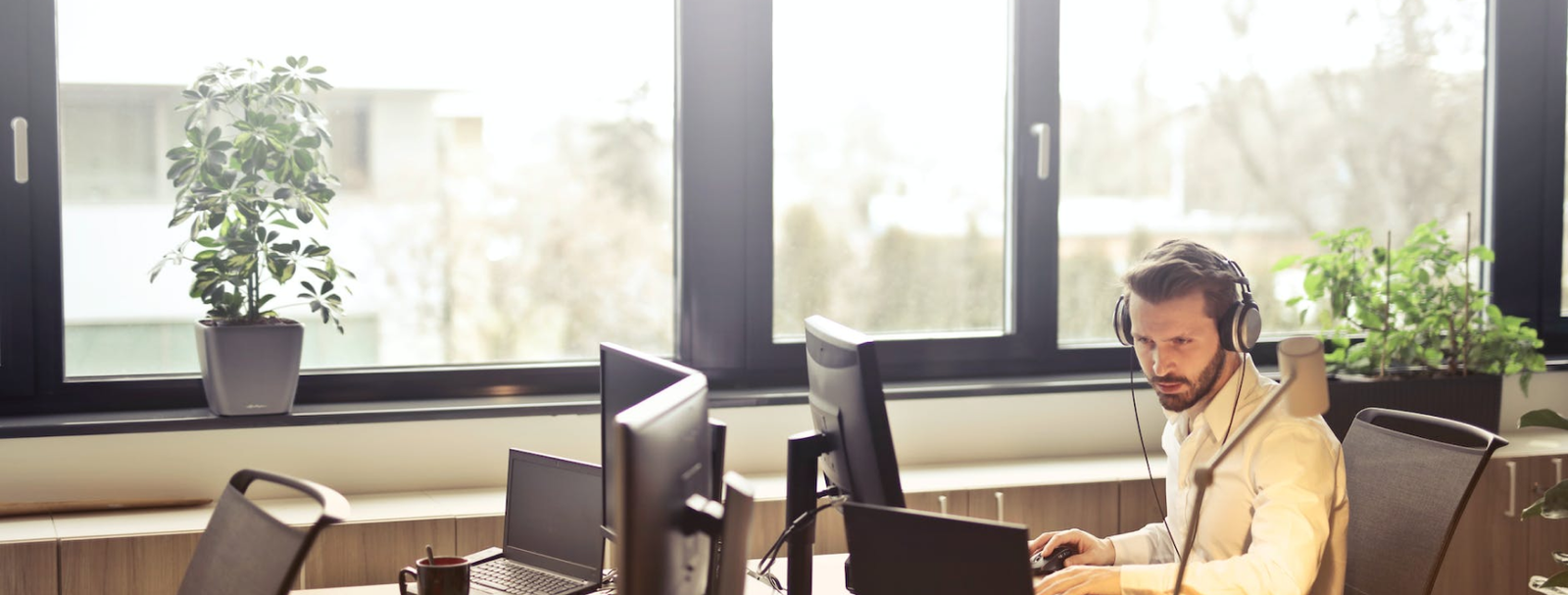 An IT support technician working across multiple monitors
